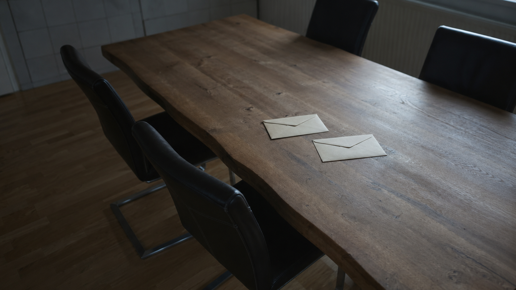 Zwei Briefe auf einem Holztisch im kühlen Morgenlicht neben einer Kaffeetasse
