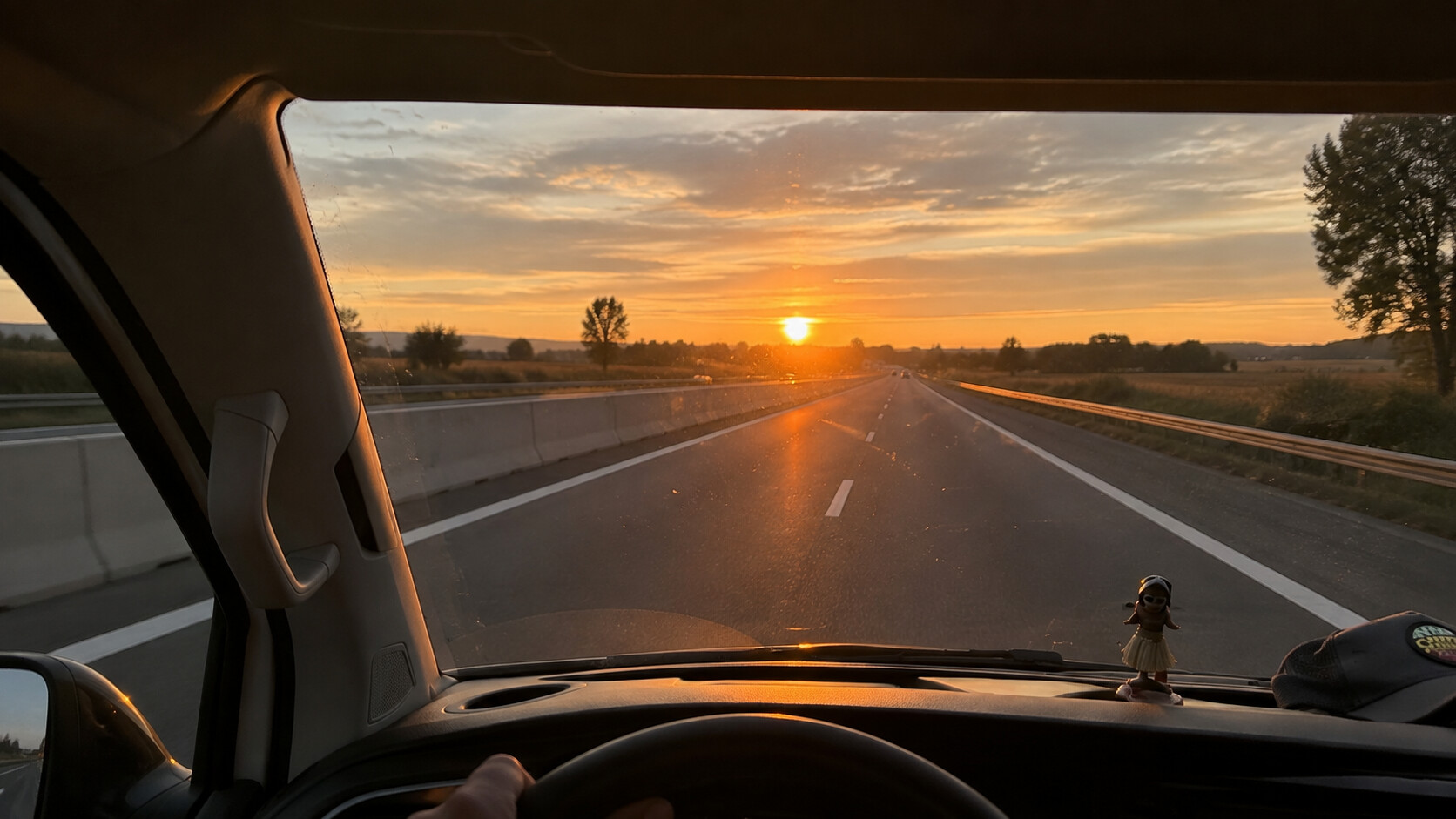 Blick durch die Windschutzscheibe eines Busses auf eine Autobahn im warmen Abendlicht
