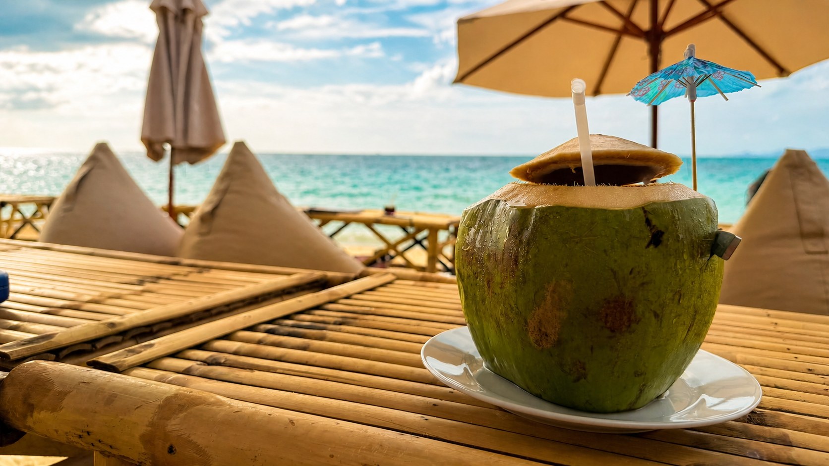 Frische Kokosnuss in der Hand vor dem Meer