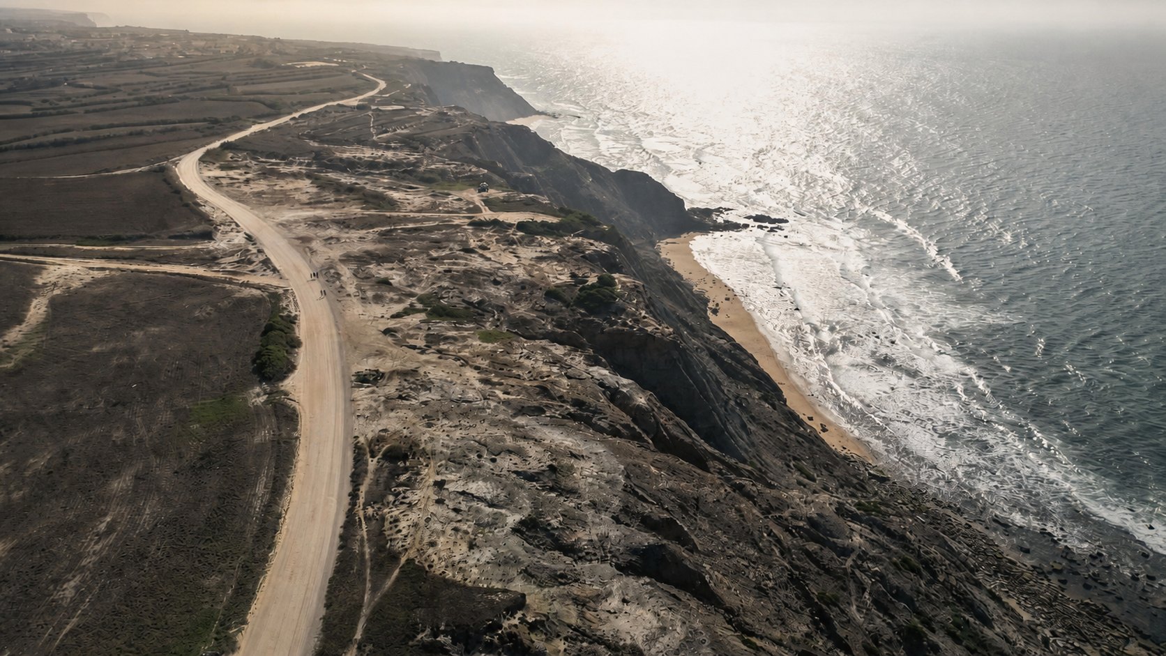 Sandige Seitenstraße, die zu einer türkisen Bucht hinunterführt