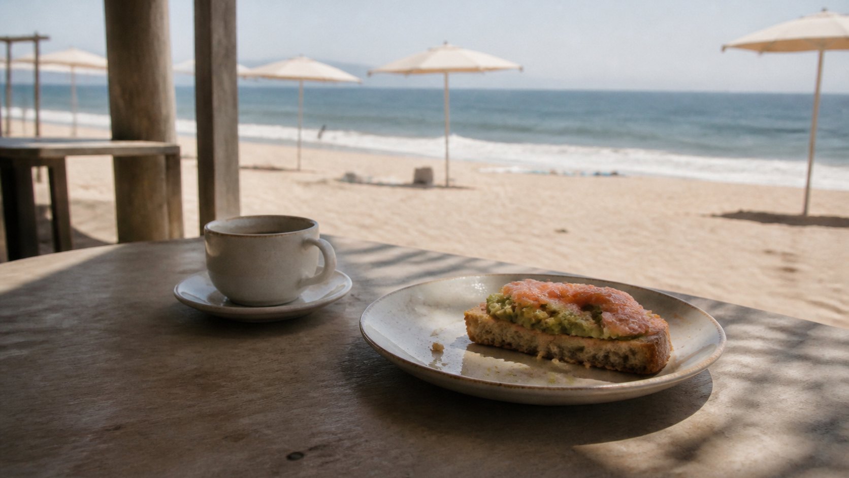 Kaffee und Avocado-Lachs-Sandwich auf dem Tisch einer Strandbar